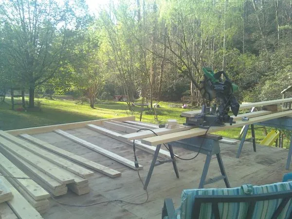 Miter saw and framing lumber on a deck under construction in Monticello